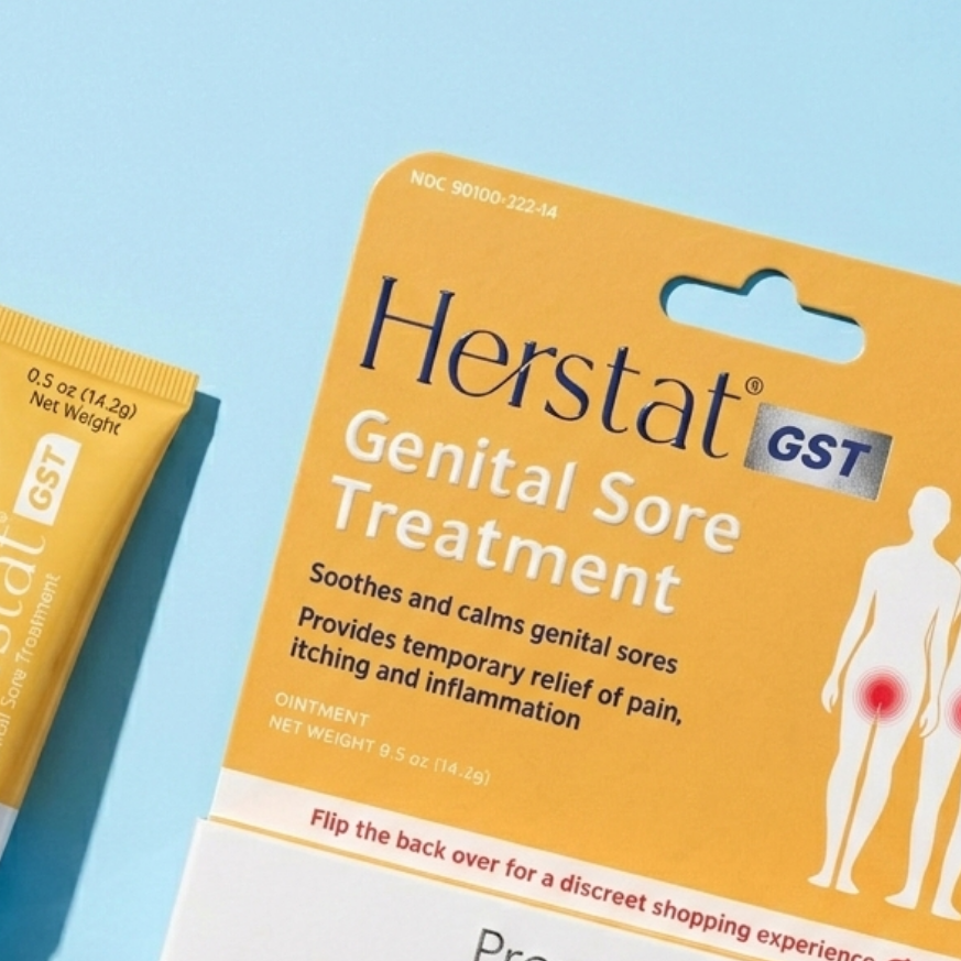 Herstat GST Genital Sore Treatment packaging and tube on a blue background